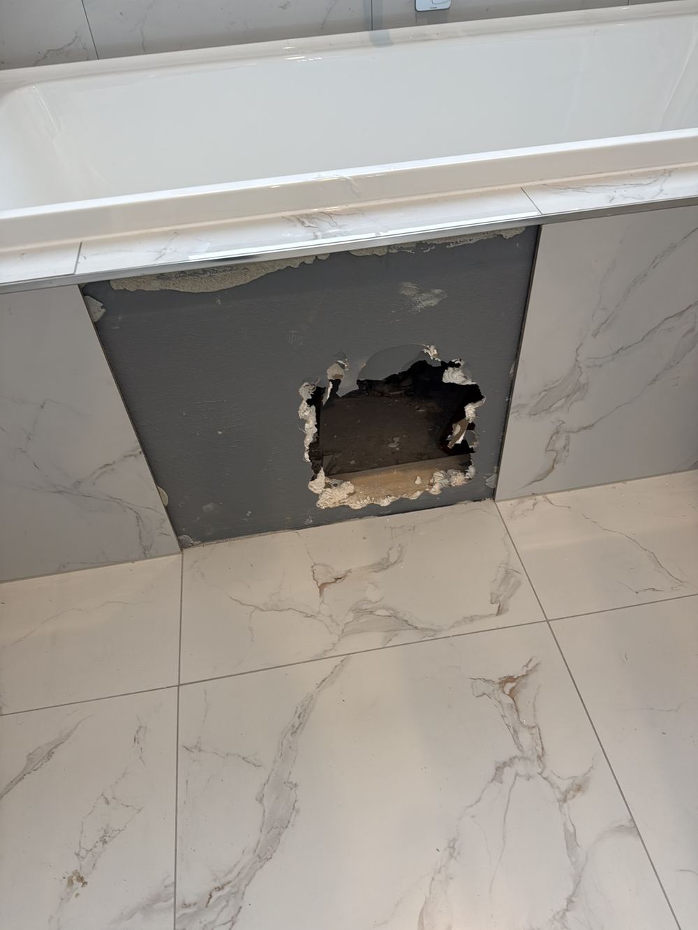 Bath hob broken open during a waste pipe fix, disturbing the waterproofing, found during a pre-handover inspection in Clyde North